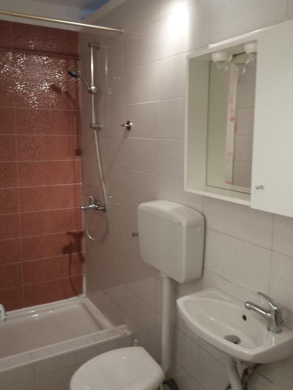 a bathroom with a toilet and a sink and a shower at Guest House Sombrero in Senj