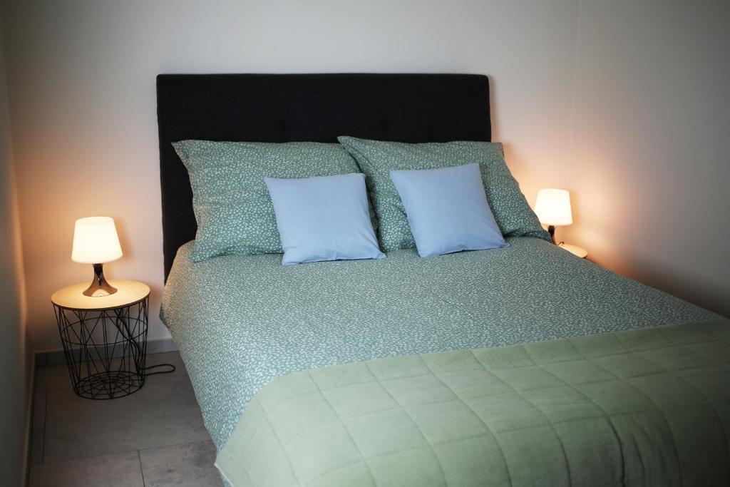 a bedroom with a bed with two blue pillows at Apartament Niechorze in Niechorze