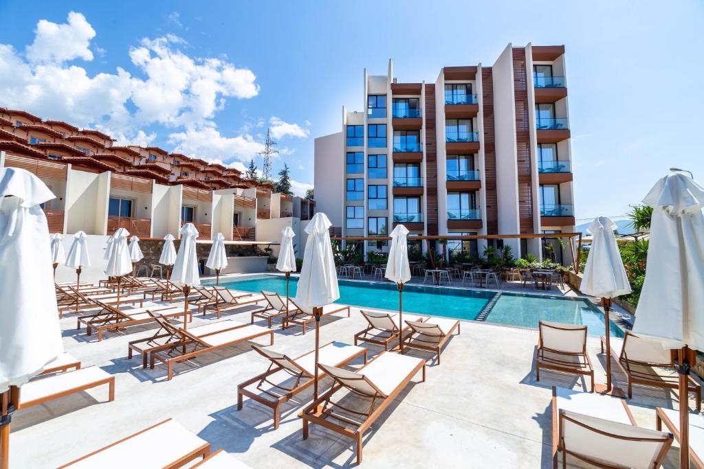 a hotel pool with lounge chairs and umbrellas at Hotel Olympia Touristic Village in Vlorë