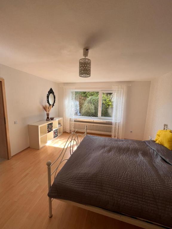 a bedroom with a large bed and a window at Ruhige Ferienwohnung im Saarland in Schiffweiler