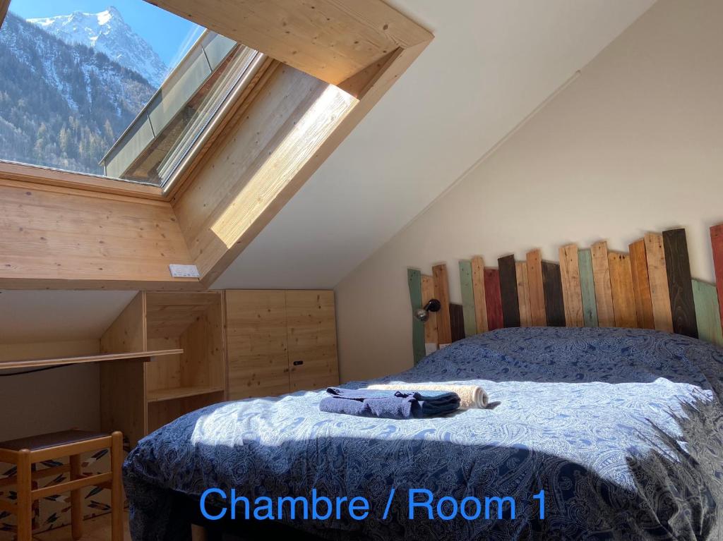 a bedroom with a bed and a window with mountains at Le Petit Cham in Chamonix-Mont-Blanc