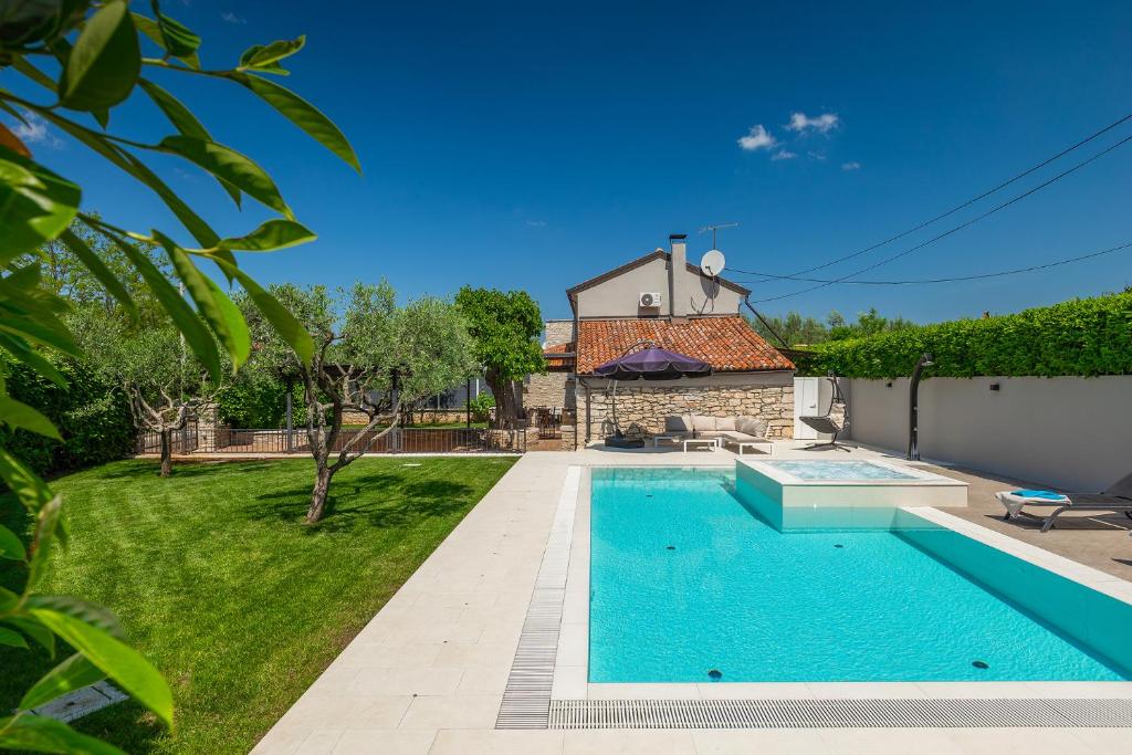 a villa with a swimming pool and a house at Villa Mala in Umag