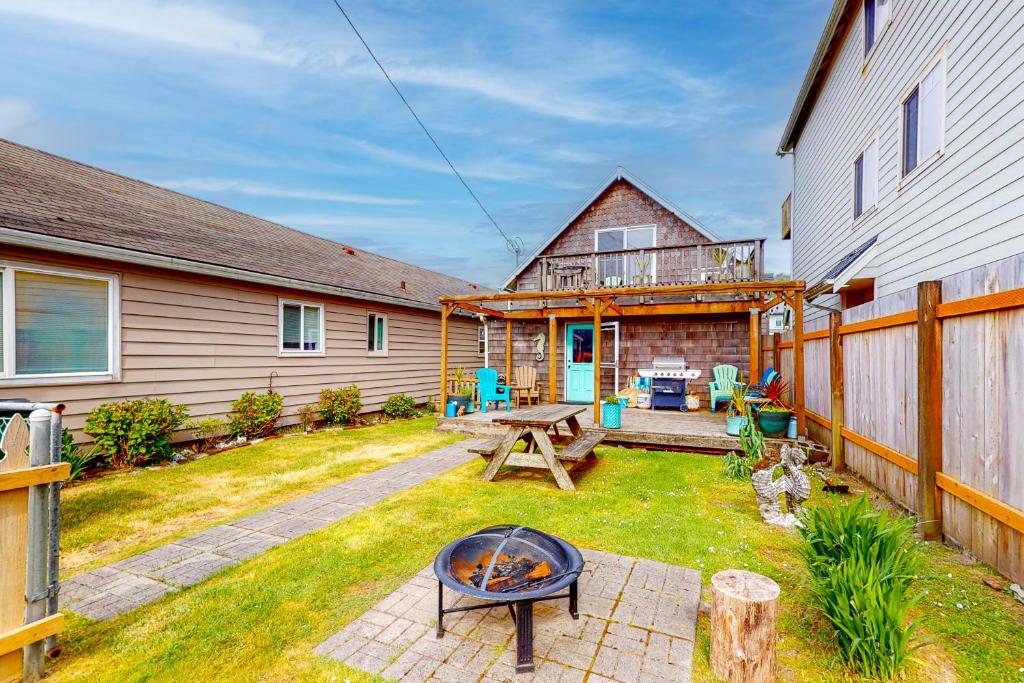 a backyard with a fire pit and a house at Ocean Shells Cottage in Rockaway Beach