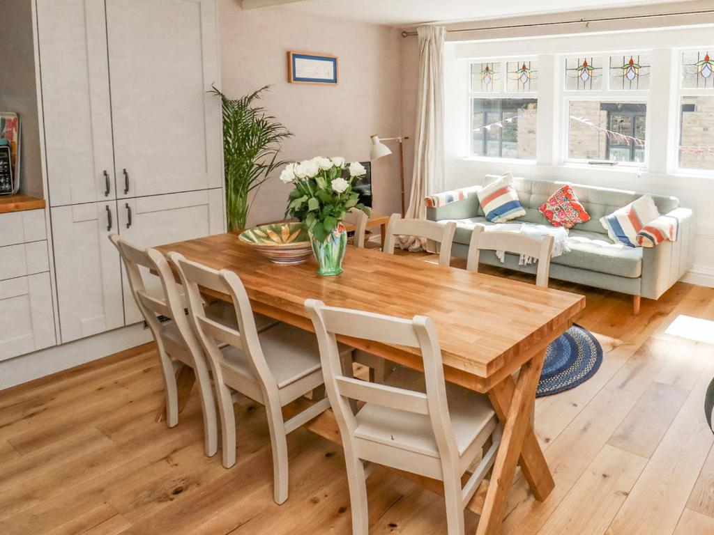 a kitchen and living room with a wooden table and chairs at Piccadilly View in Keighley