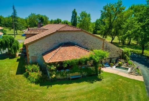 a small house with a roof on a green yard at Gîte le domaine de Dolly in Villeneuve-sur-Lot