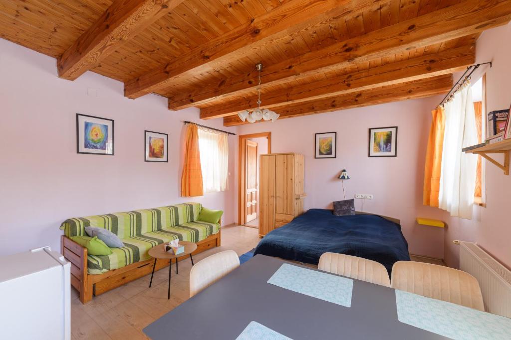 ein Wohnzimmer mit einem Bett und einem Tisch in der Unterkunft Apartman egy Makovecz Imre tervezte házban in Ispánk