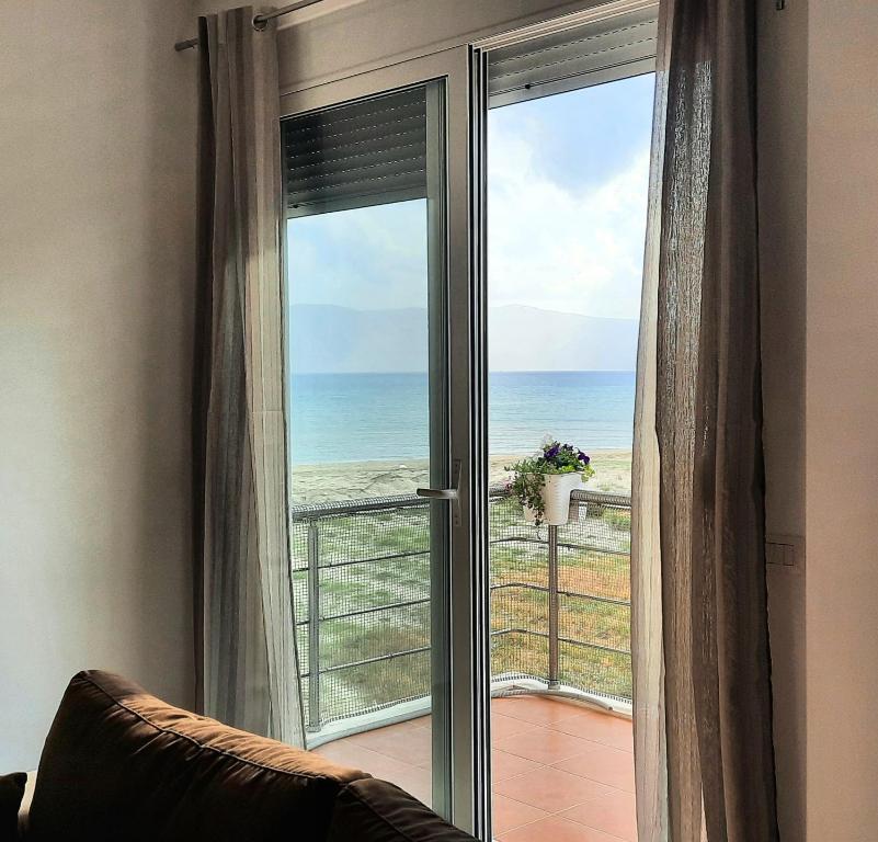 una puerta corredera de cristal con vistas al océano en Antea Apartments 1-2, en Vlorë