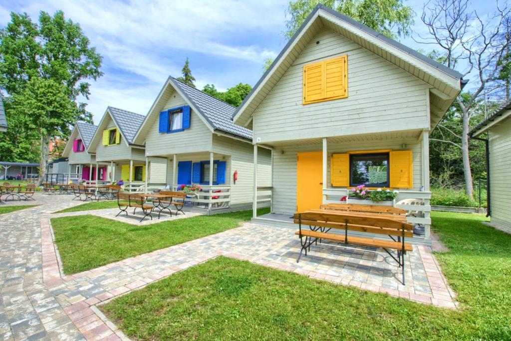 szereg domów z ławką w ogródku w obiekcie Kolorowe Domki Rewal w Rewalu