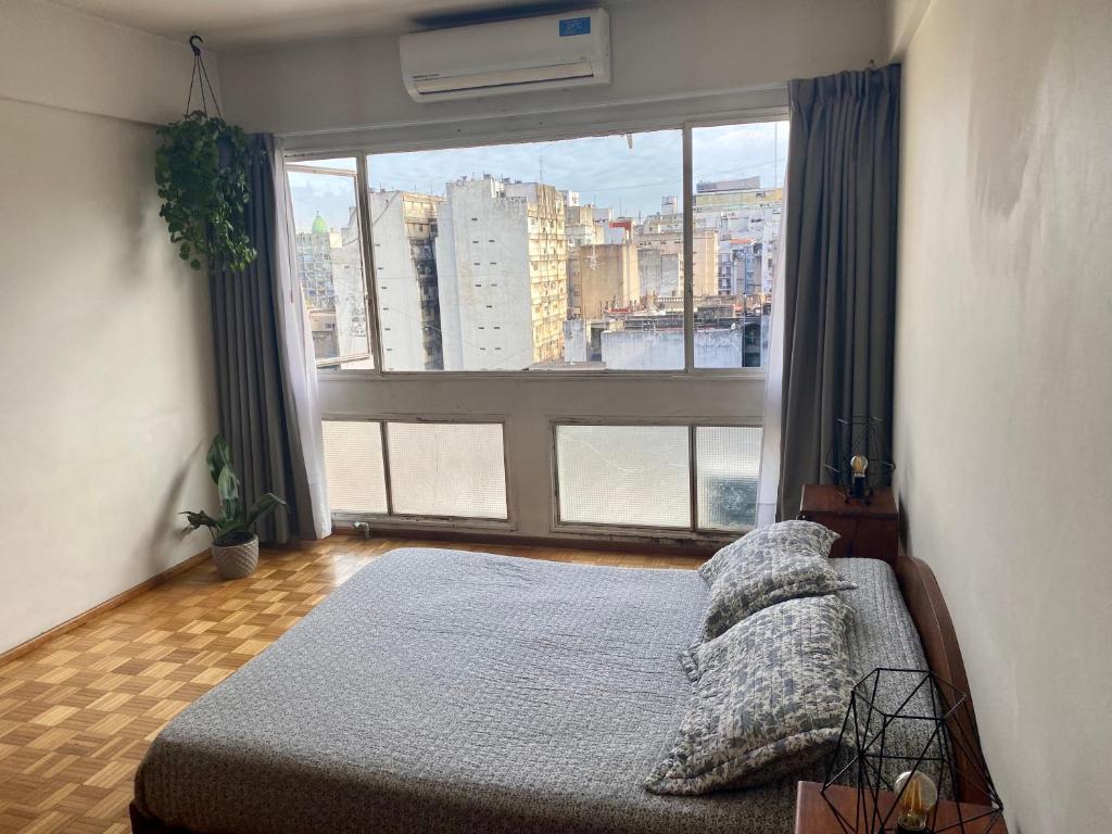 1 dormitorio con cama y ventana grande en Monoambiente en el Obelisco, cochera opcional en Buenos Aires