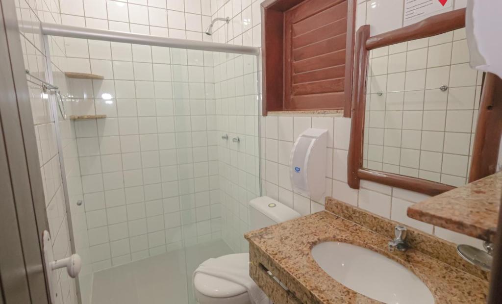 a bathroom with a toilet and a sink and a mirror at Pousada Saudosa Maloca in Arraial d'Ajuda