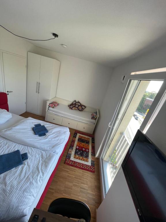 a small bedroom with a bed and a television at Boutique Zimmer Privat 1-4 Personen in Frankfurt/Main