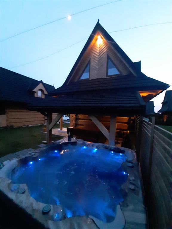 a gazebo with a blue pool in a backyard at MALCYKÓWKA - domki góralskie in Ząb