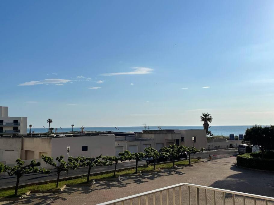 a view of a parking lot with the ocean in the background at le Barcarès appartement bord de mer in Le Barcarès