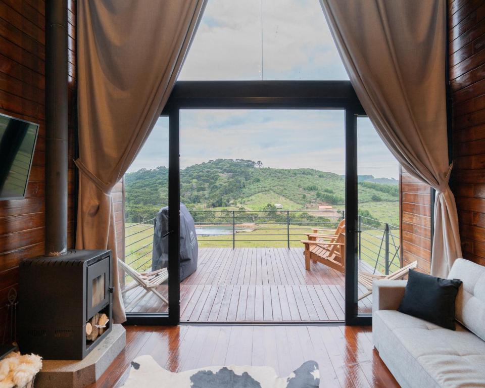 un soggiorno con camino e una grande finestra di Nordic Cabanas a Cambará