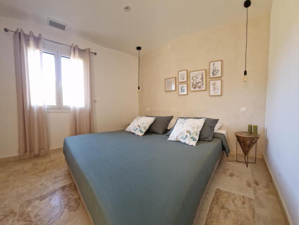 a bedroom with a blue bed and a window at Domaine U Filanciu, Maison Ghjulia avec piscine - Centre Corse in Moltifao