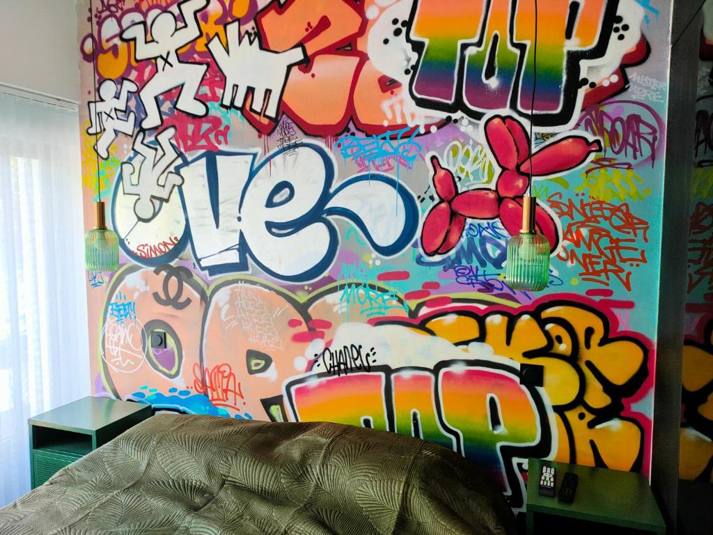 a room with a wall covered in graffiti at Chambre Street Art in Capbreton