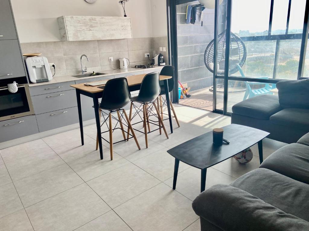 uma cozinha com mesa e cadeiras numa sala de estar em Beauty apartment 3 rooms wi-fi em Netanya