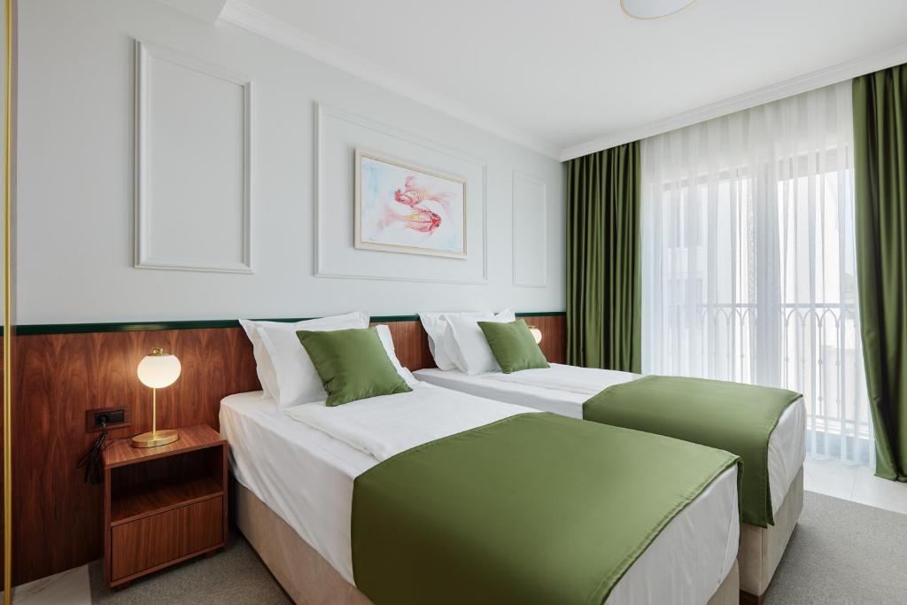 una camera d'albergo con due letti e una finestra di Hotel Diplomat a Budua
