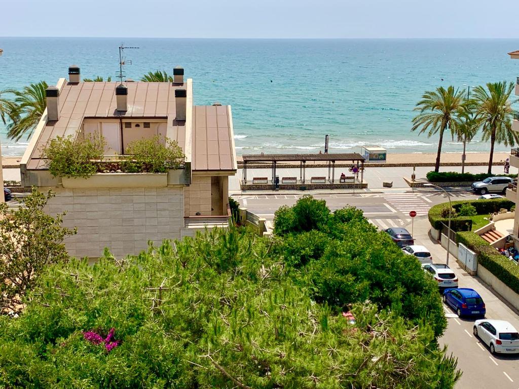 a building next to the ocean with a parking lot at Penthouse w/ sea view, pool & beach in Calafell