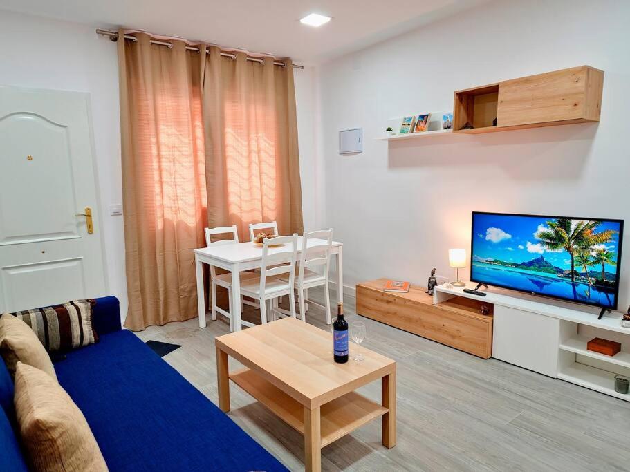 een woonkamer met een bank, een tv en een tafel bij Apartamentos Bielsa 'Madrid Río' in Madrid