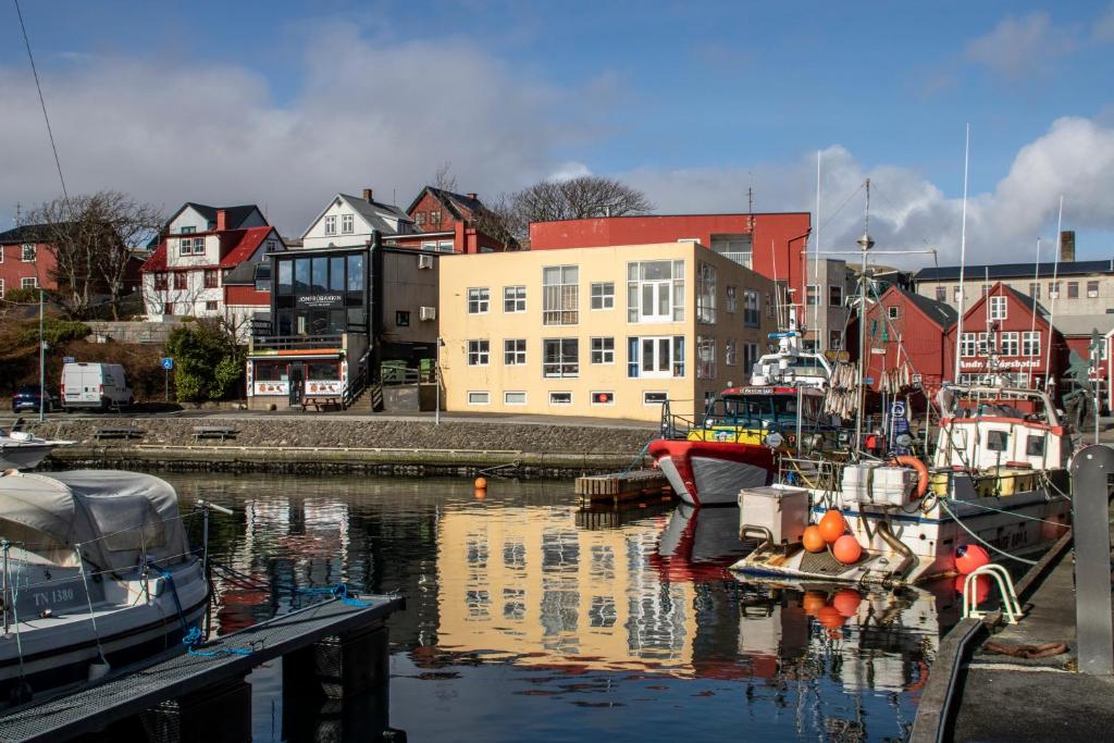 a group of boats are docked in a harbor at Guesthouse at the boat harbour in Tórshavn