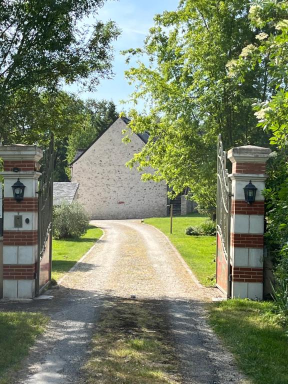 a driveway leading to a house with two gates at Les gîtes de La Pellerie - 2 piscines &amp; spa Jacuzzi - Touraine - 3 gîtes - familial, calme, campagne in Saint-Branchs