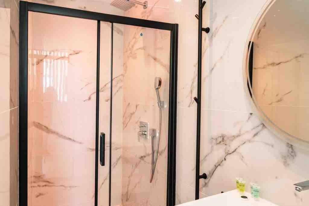 W łazience znajduje się prysznic, umywalka i lustro. w obiekcie Suite luxe jacuzzi w Cannes