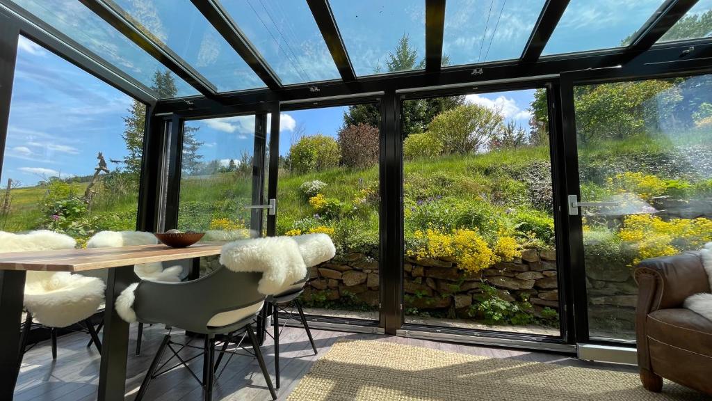 a conservatory with a table and chairs looking out onto a garden at Flügels ReBi-Baude in Rechenberg-Bienenmühle