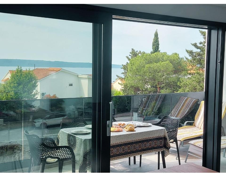 einen Tisch und Stühle auf einem Balkon mit Aussicht in der Unterkunft Sun Side - Čiovo in Trogir