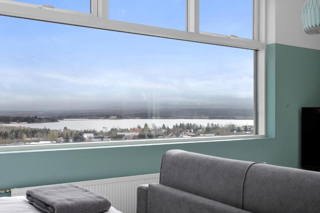 a room with a large window with a view of a lake at Icelandic Apartments by Heimaleiga in Reykjavík