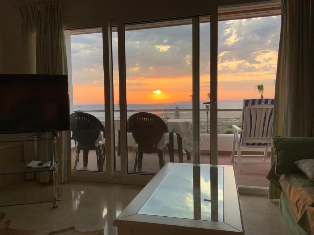 een woonkamer met uitzicht op de zonsondergang bij Casa del Mar in Zahara de los Atunes