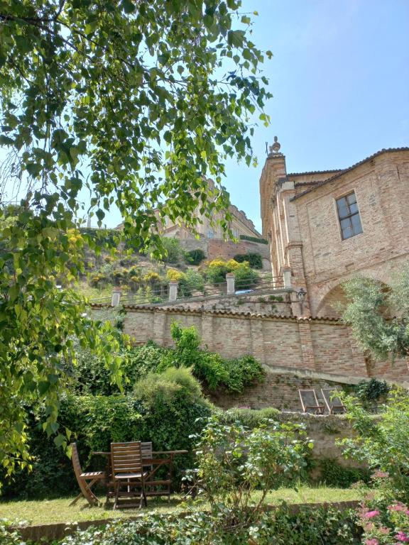 un banco del parque frente a un edificio de ladrillo en Il giardino di Olivia, en Guarene