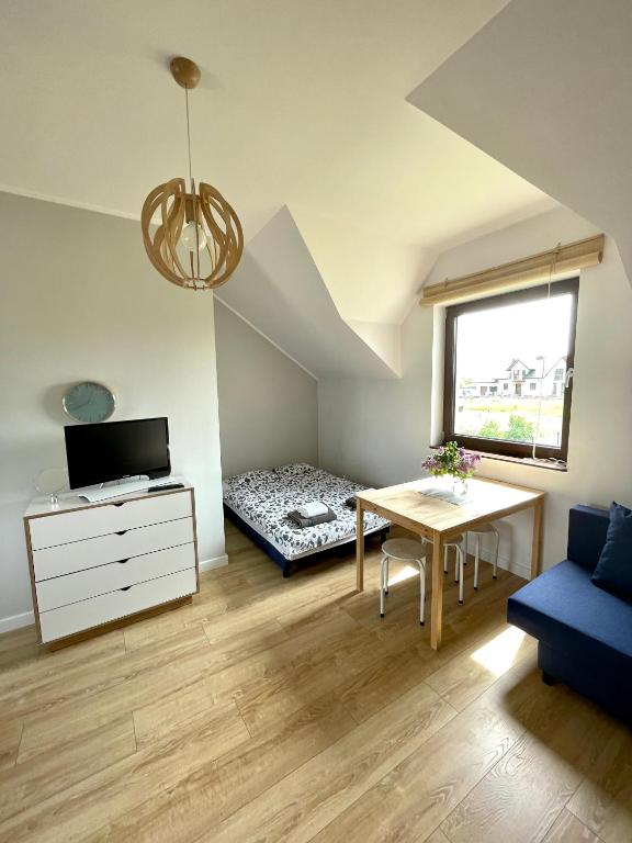 a small room with a desk and a bed and a table at Apartament letni Almar in Pogórze