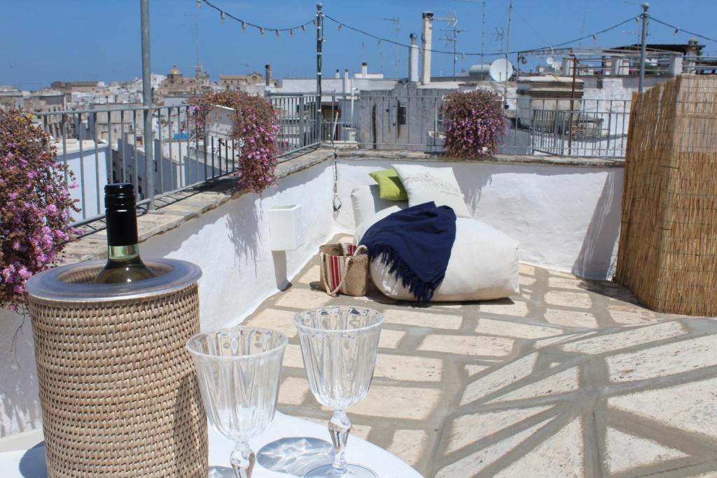 - une table avec des verres à vin sur le toit dans l'établissement L'Angolo di Ostuni - Home&Terracex4, à Ostuni