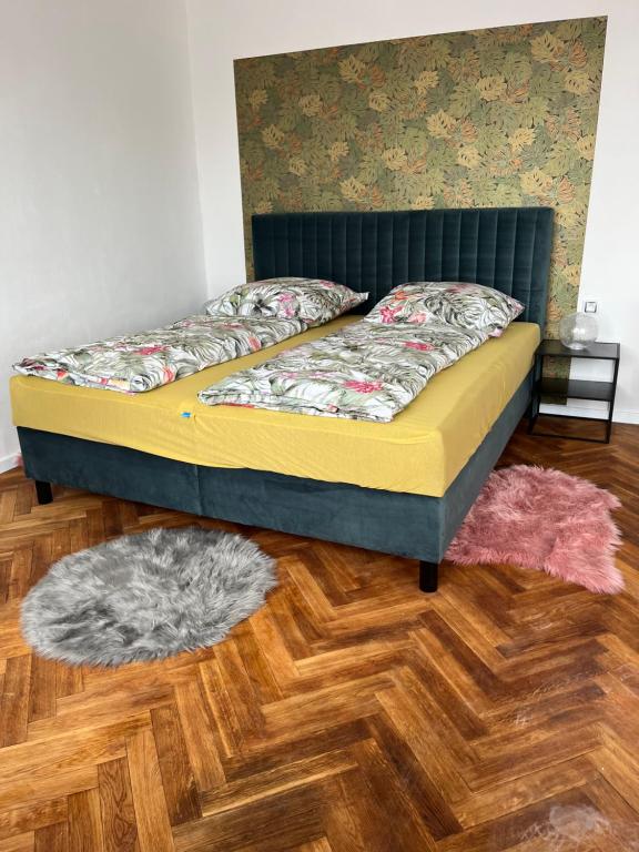 Bett in einem Zimmer mit Holzboden in der Unterkunft Apartmán Monstera in Kolín