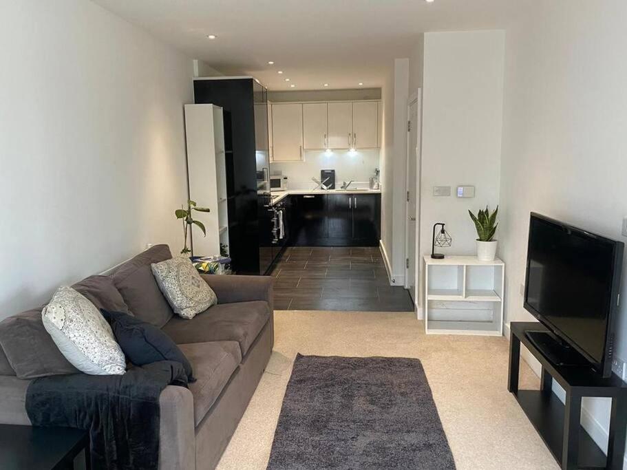 a living room with a couch and a kitchen at Stylish 3 beds North Greenwich 02 Arena Apartment in London