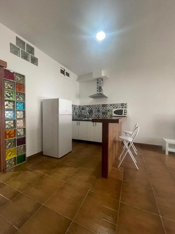 a kitchen with a refrigerator and a table in it at Apartamento monte dorado in Málaga