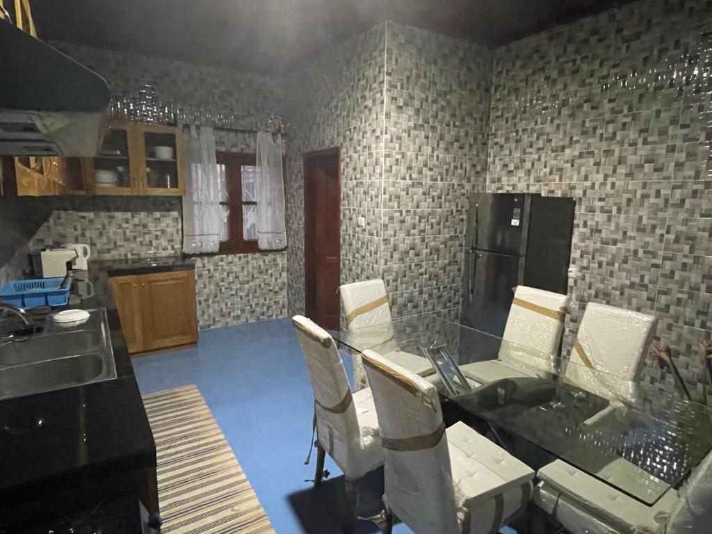 a kitchen with a table and chairs in a room at Tropical Paradise in São Tomé