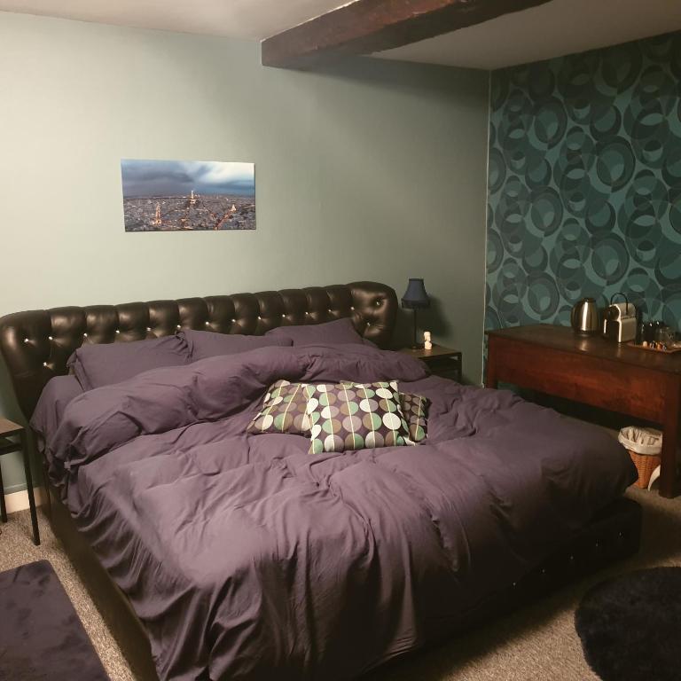 a bedroom with a bed with a purple comforter at Cour st Didier in Nevers