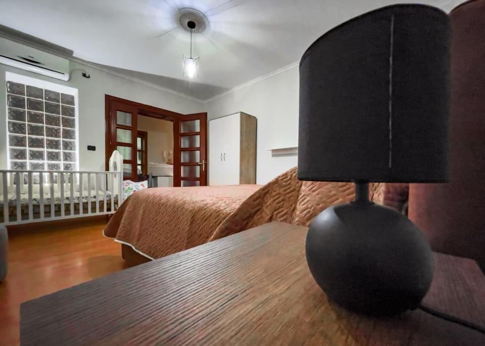 1 dormitorio con 1 cama y 1 mesa con lámpara en Vila Kodra en Tirana