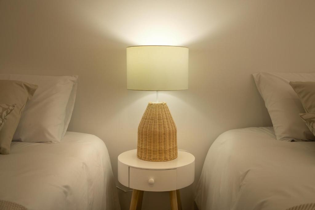 una lámpara sentada en una mesa entre dos camas en Casa da Fonte, 
