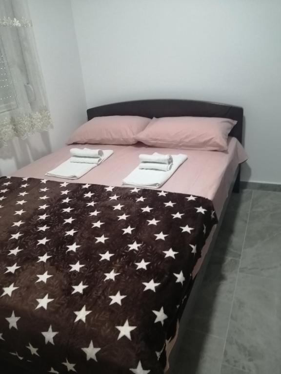 a bed with a black blanket with white stars on it at Apartman Jela in Soko Banja