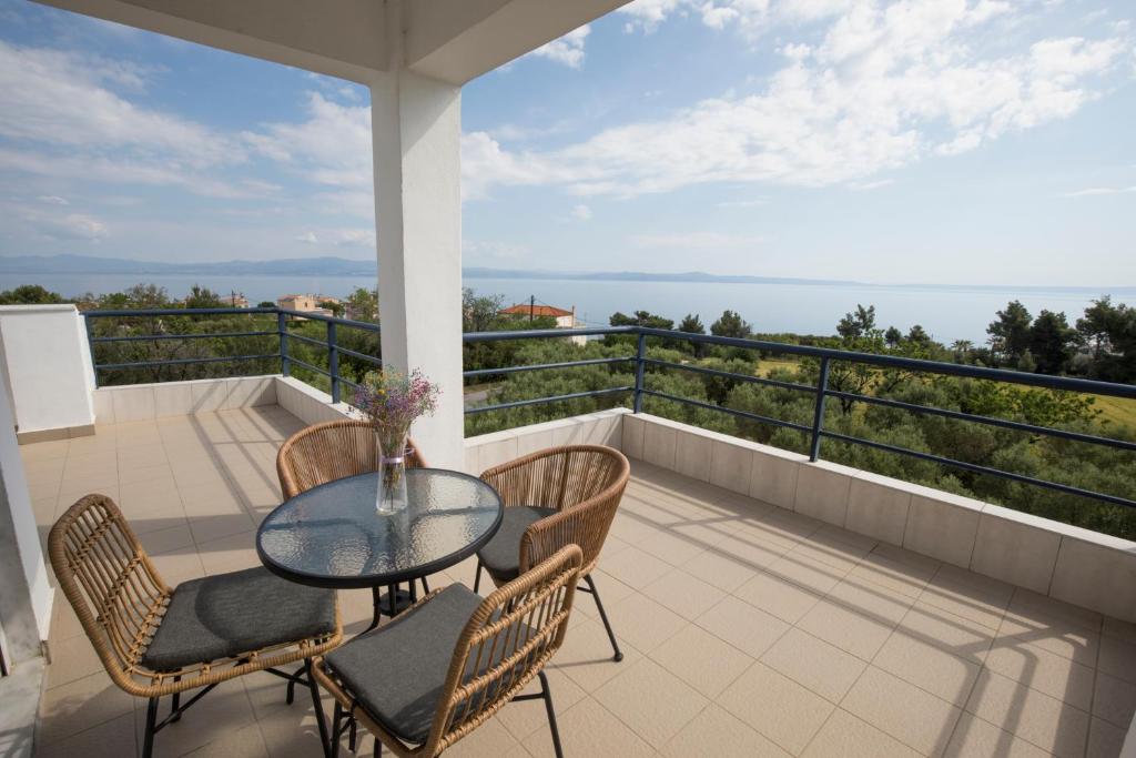 a patio with a glass table and chairs on a balcony at Kahlenberg apartments in Afitos