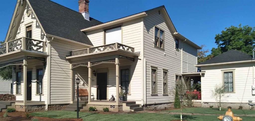 una casa blanca con techo negro en HISTORICAL JOHN RAST HOUSE circa 1875 en Roseburg