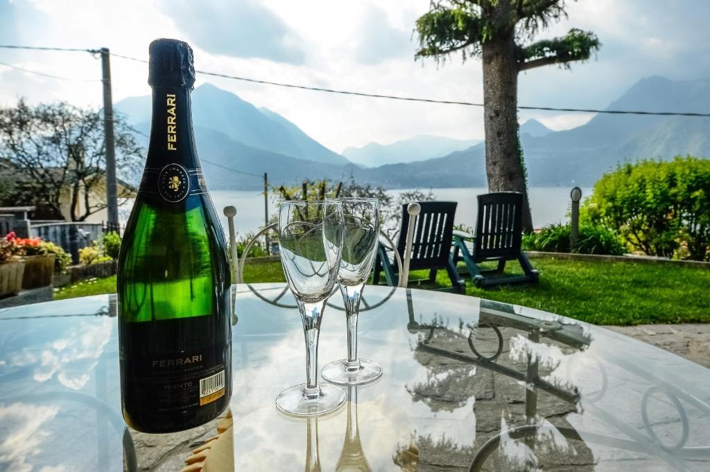 una botella de vino y dos copas de vino en una mesa en Villa Bianca, en Varenna