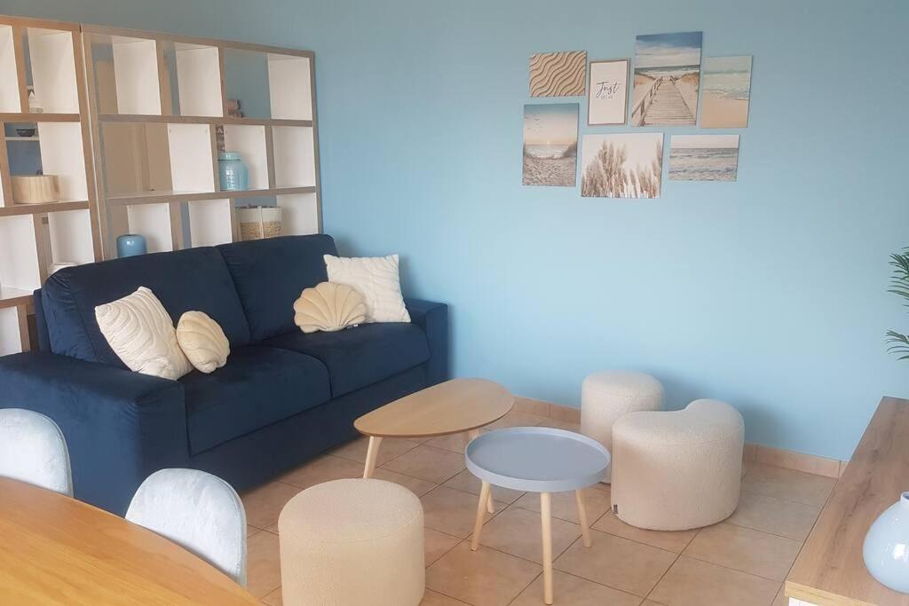 a living room with a blue couch and tables at La MAISON BLEUE, Smeg Bleu azur in Évian-les-Bains