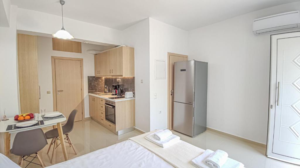 a kitchen with a stainless steel refrigerator and a table at Fully renovated Studio in Platanias in Plataniás