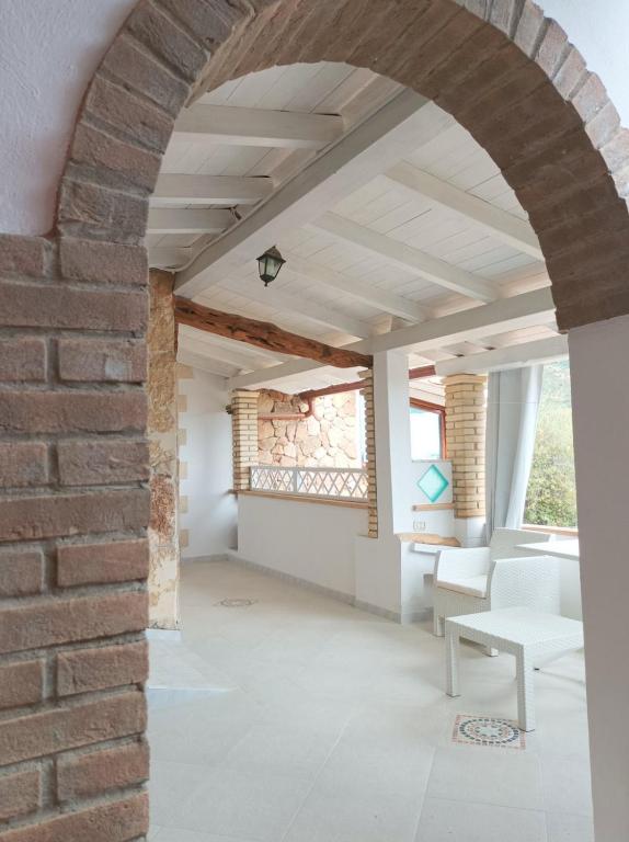an archway in a room with a brick wall at Sardinia Yellow House in Solanas
