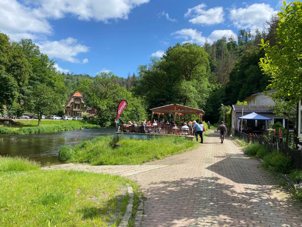 un grupo de personas caminando por un camino junto a un río en Pension Sternschnuppe, Treseburg Harz mit Biergarten & Restaurant, tierfreundlich, en Thale