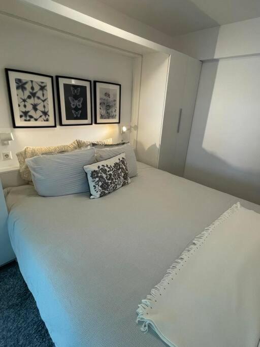 un letto bianco con due cuscini sopra di Charming Coastal Retreat ad Anávissos